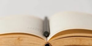 Open book with pen laying in the middle
